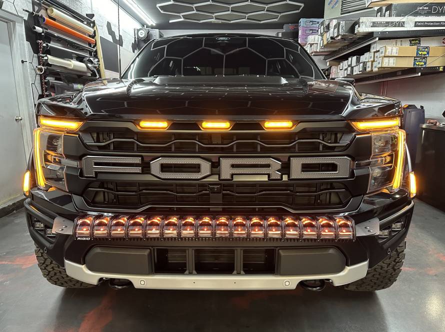 Close-up of custom LED headlights on electric vehicle during detailing