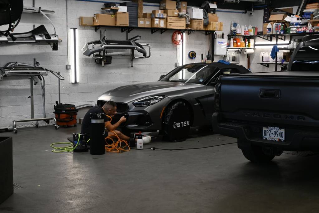 Applying PPF to front bumper of sports car
