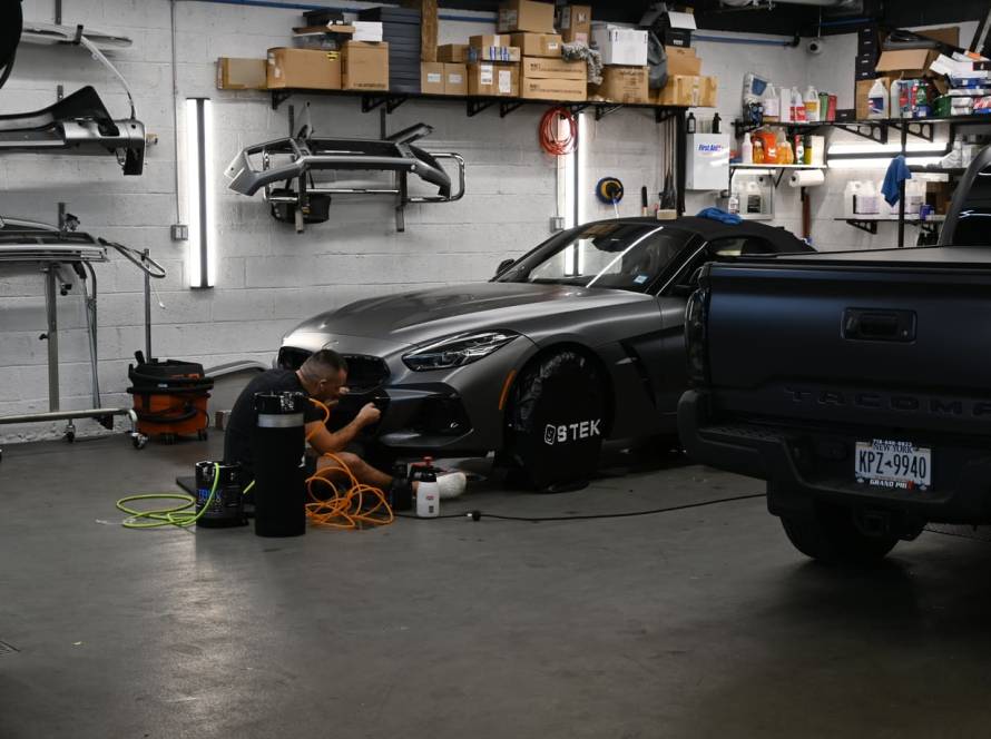 Applying PPF to front bumper of sports car