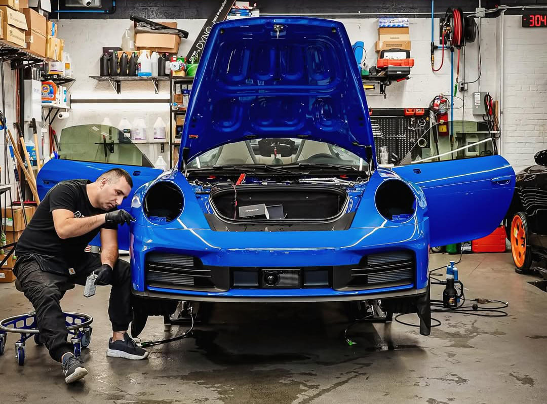 Applying paint protection film to a vehicle’s hood with squeegee tool