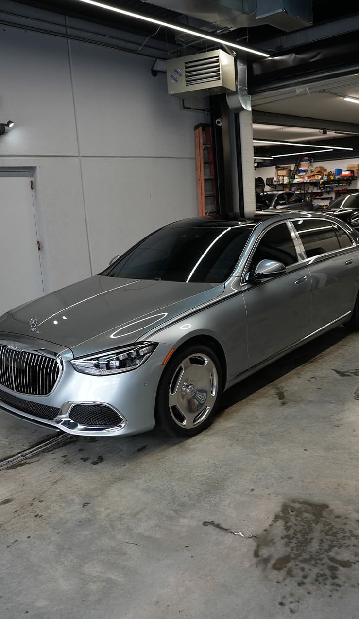 Preparing a Mercedes for STEK PPF Installation – Grand Prix Customs Brooklyn Technician cleaning Mercedes surface before STEK Paint Protection Film installation at Grand Prix Customs in Brooklyn, NY